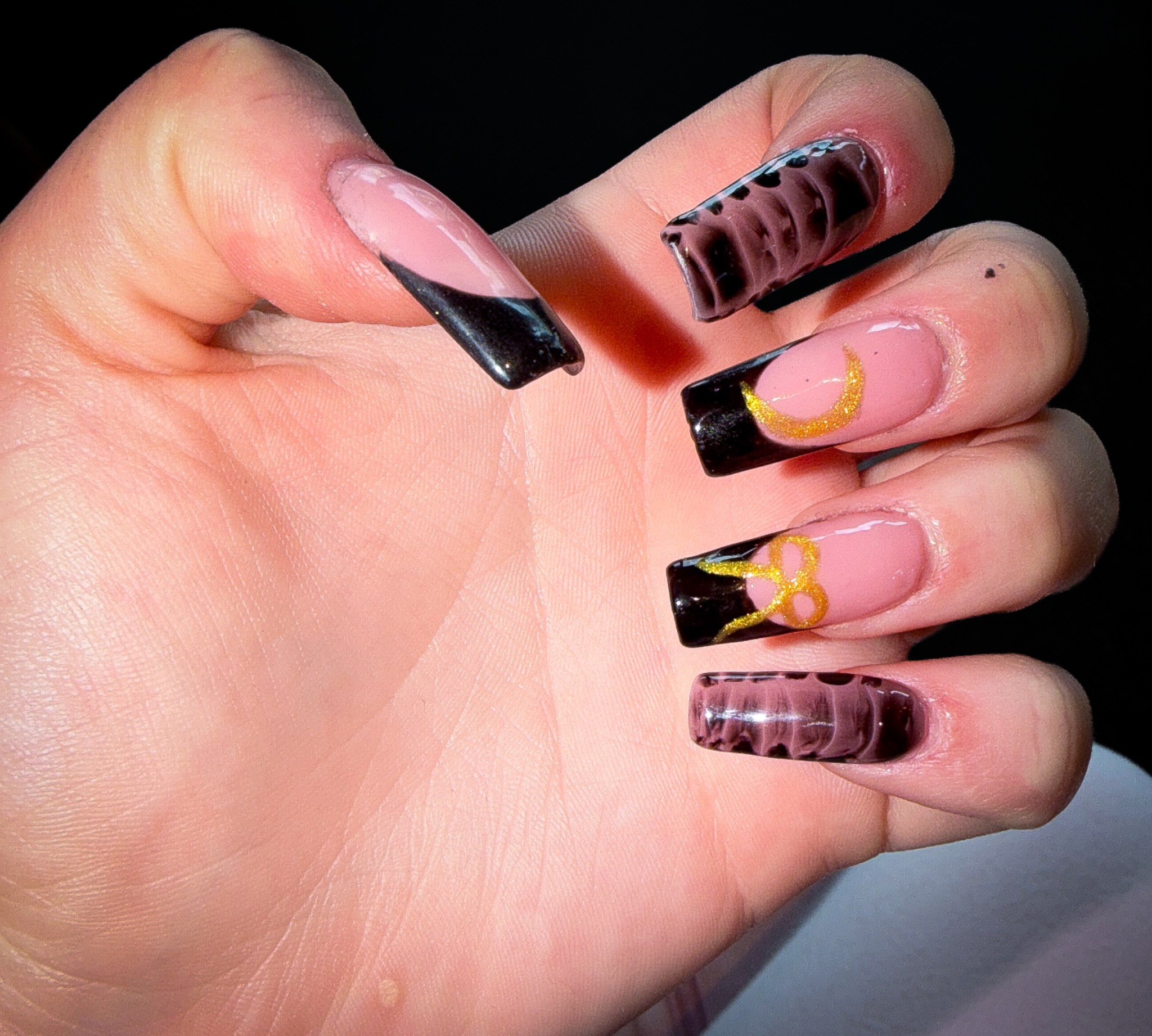 Black and mauve square nails with gold moon and bow accents