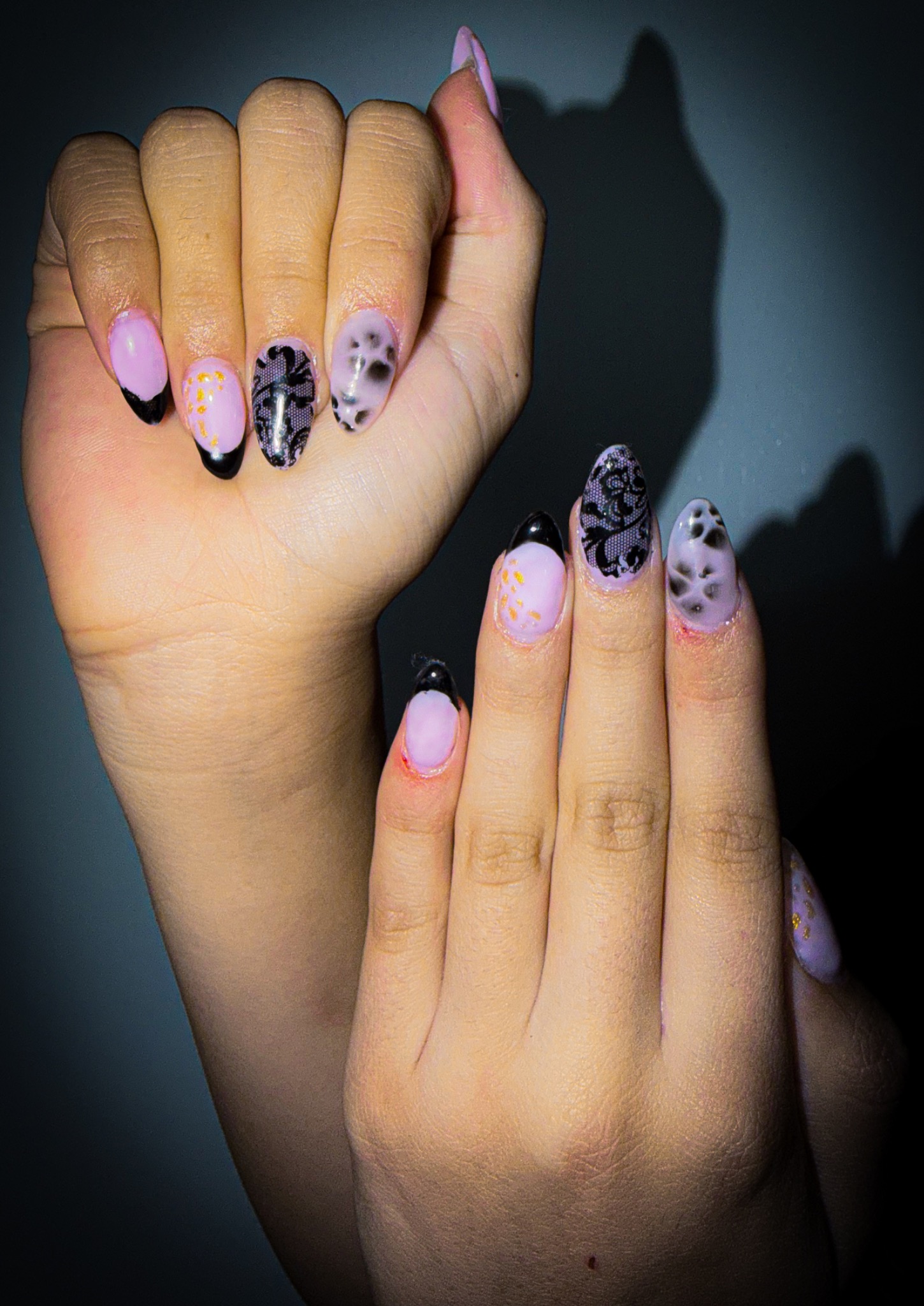 Lavender and black nail art with lace patterns and gold accents