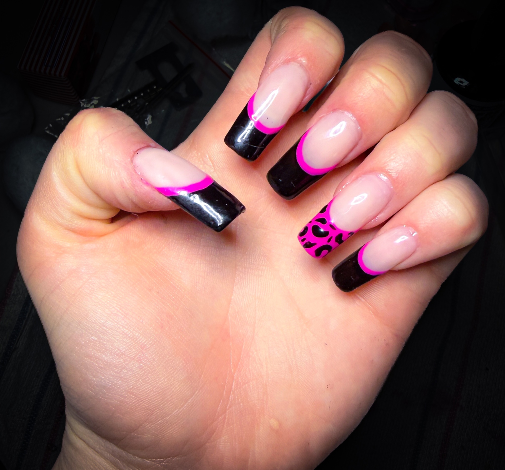 Black French tips with hot-pink outlines and a leopard-print accent nail